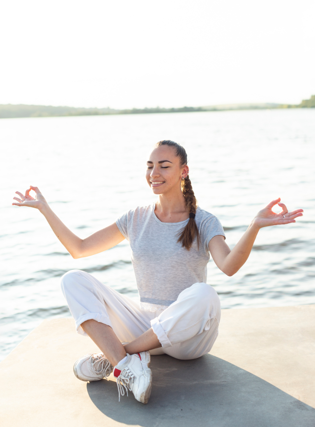 Person meditating on beach